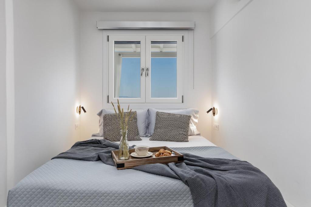 a bedroom with a bed with a tray of food on it at Terrace Sky View in Naxos Chora