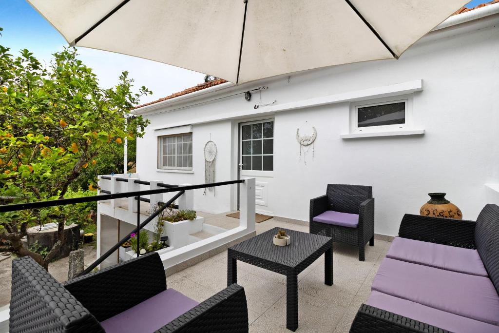 une terrasse avec des chaises, une table et un parasol dans l'établissement Casa Kiko, à Anha