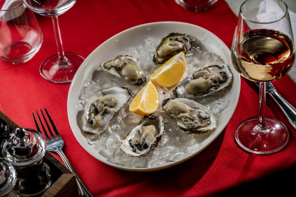 a plate of oysters with lemon slices on a table at Hotel Cvita in Split
