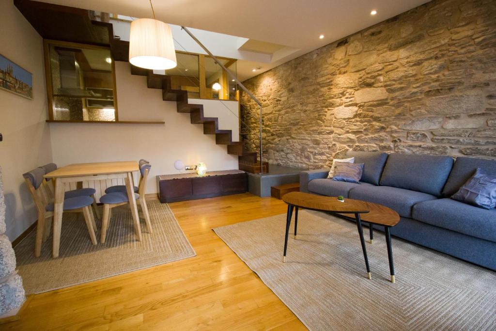 a living room with a blue couch and a table at Apartamentos Turísticos Pacios in Santiago de Compostela
