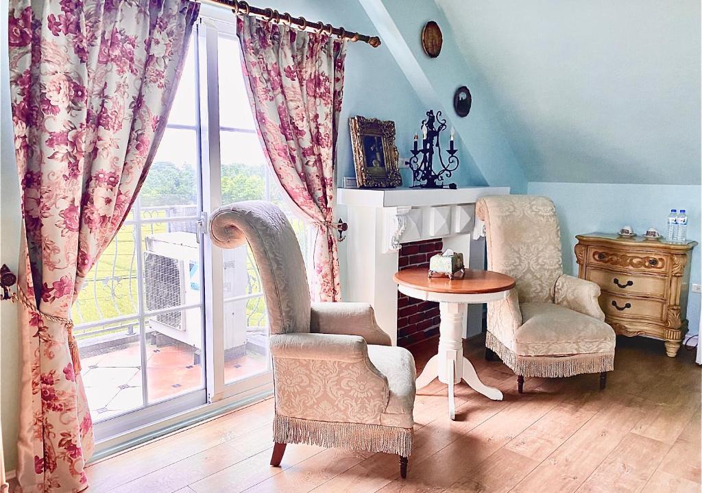 a room with two chairs and a table and a window at England Castle B&amp;B in Wujie