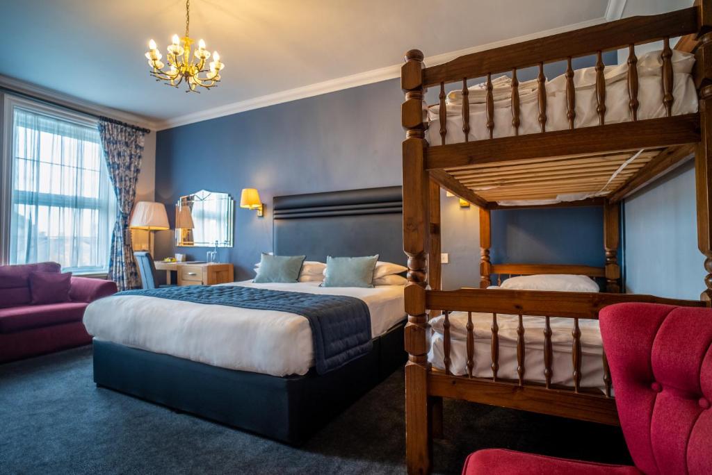 a bedroom with a bunk bed and a couch at Balmer Lawn in Brockenhurst