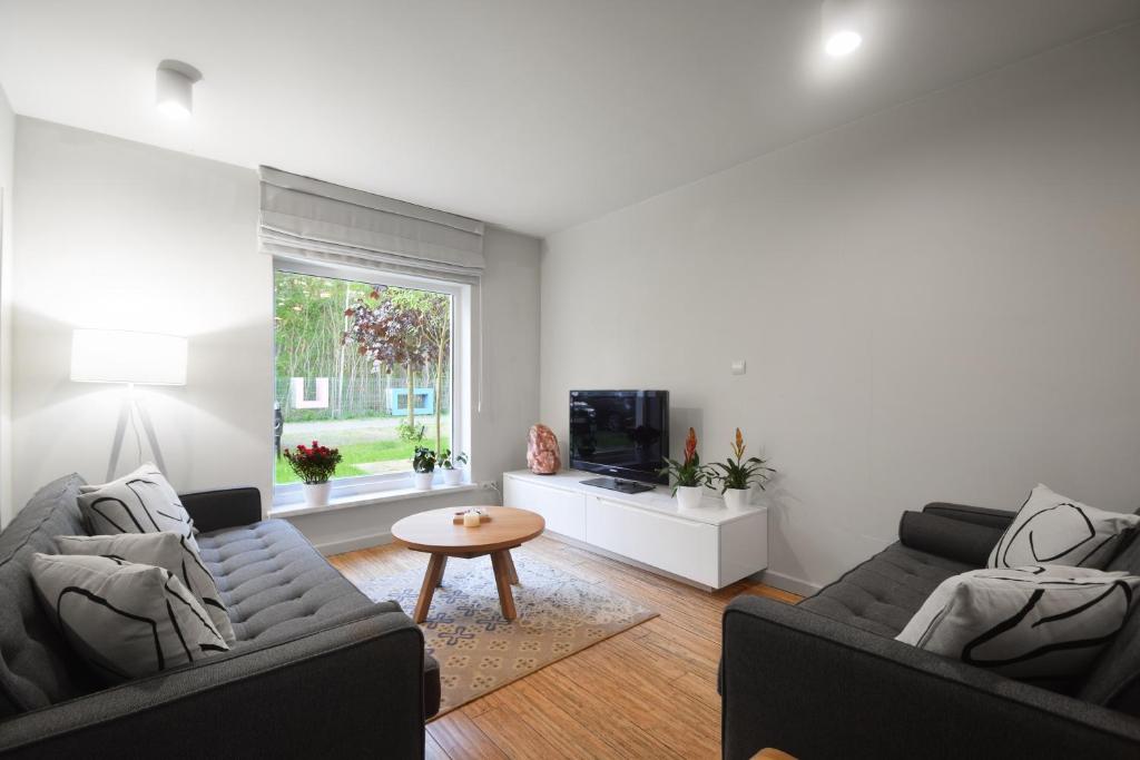 a living room with two couches and a tv at Apartament Mare Baltico in Pogorzelica