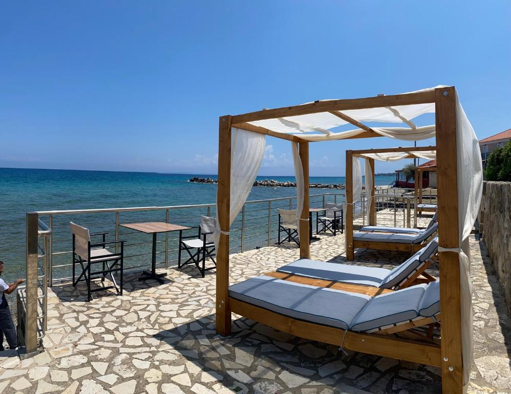 a group of beds on the beach near the water at Amaltheia Beach Front Houses in Kypseli