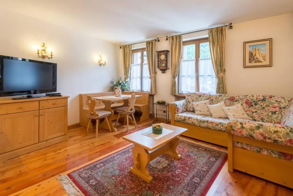 - un salon avec un canapé et une table dans l'établissement Cozy apartment near Cortina, à San Vito di Cadore