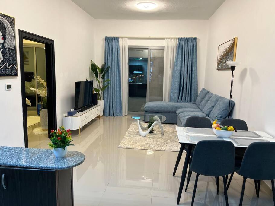 uma sala de estar com um sofá e uma mesa em Spacious Cozy Brand New 1 Bedroom Apartment em Dubai