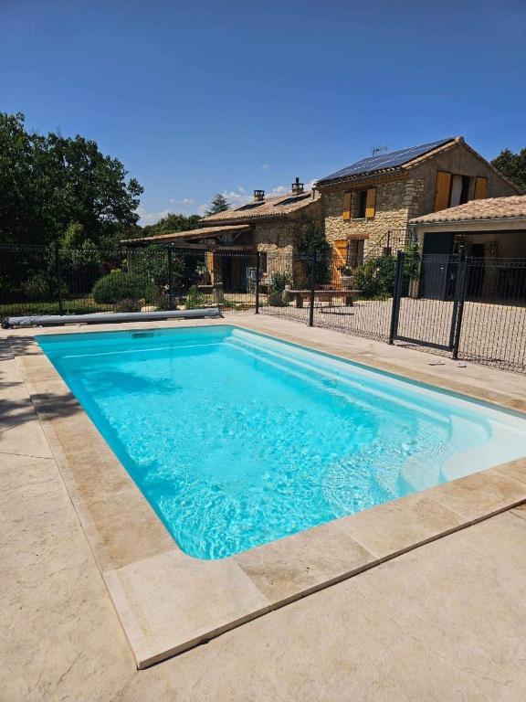 une grande piscine bleue devant une maison dans l'établissement Le Mas de Lou Papé, à Carsan