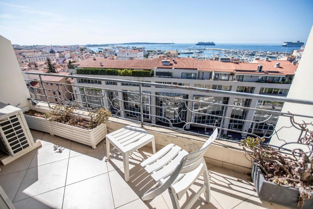 un balcon avec deux chaises et une vue sur une ville dans l'établissement The View Studio by Connexion, à Cannes