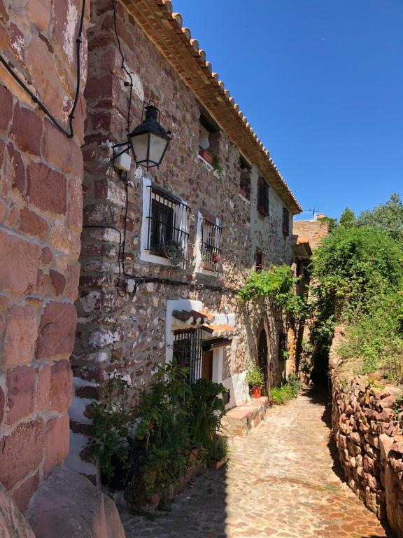 een oud stenen gebouw met een straat bij El Refugi in Vilafames