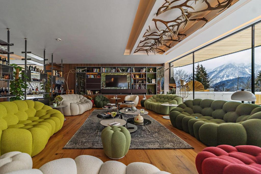 a living room with couches and a television and mountains at Chalet Sofija in Gozd Martuljek