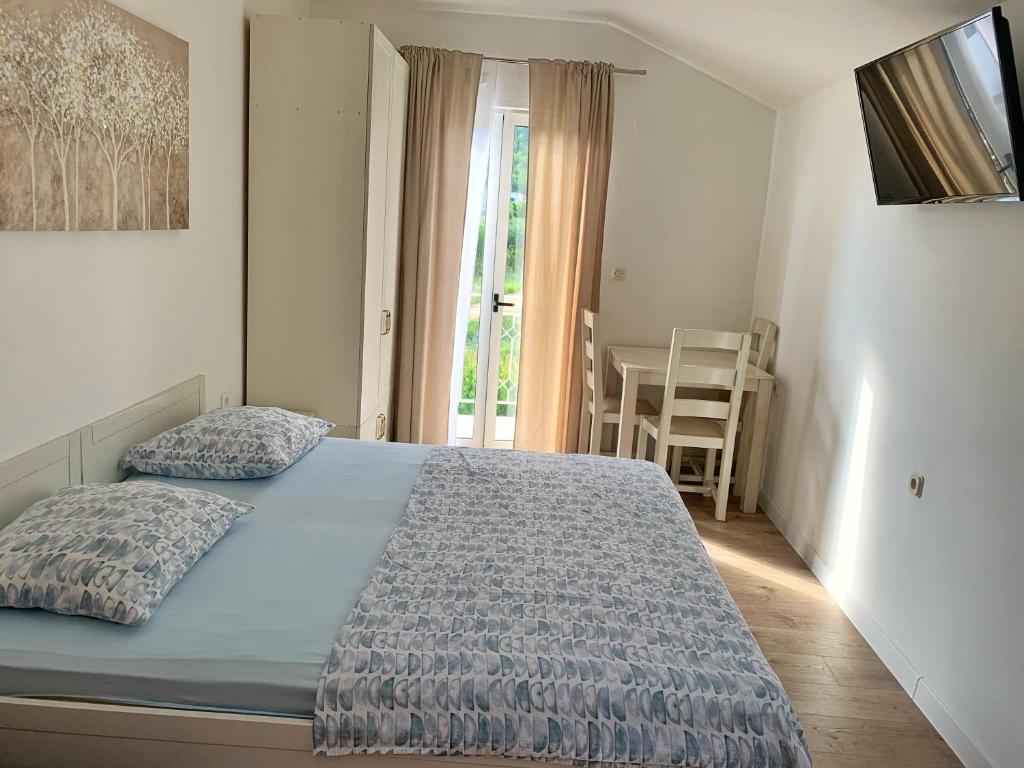 een slaapkamer met een bed met een blauw dekbed bij Apartments Villa Antony 2 in Drvenik