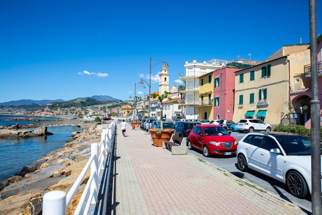 uma rua da cidade com carros estacionados ao lado da água em La casa di Tina a 20 metri dal mare em Santo Stefano al Mare