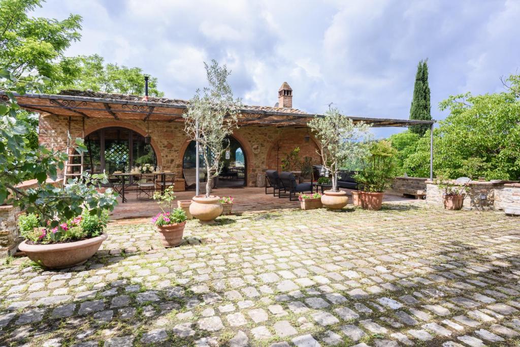 une terrasse en pierre avec des plantes en pot devant une maison dans l'établissement Villa Fienile Design, à SantʼAppiano