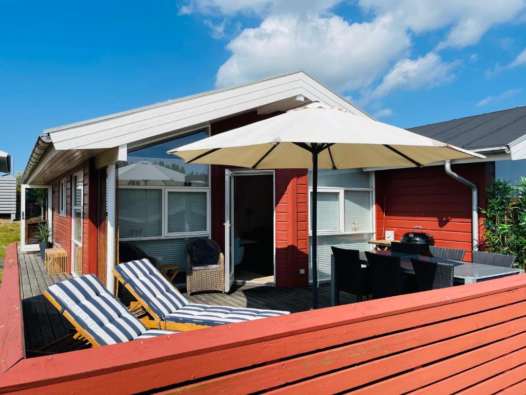 un patio con due sedie e un ombrellone di Sommerhus Dänemark a Tranekær