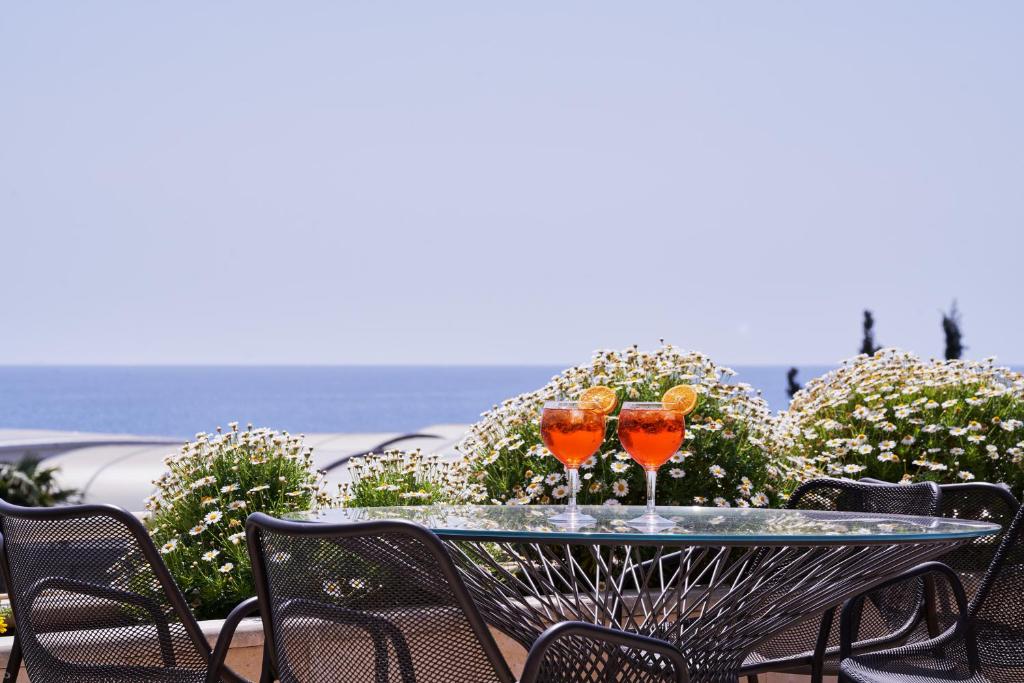 two wine glasses sitting on a table on a patio at Atlantica Bay - Adults Only in Limassol