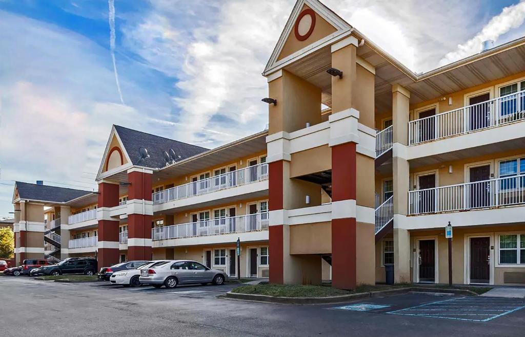 MainStay Suites Knoxville - Cedar Bluff في نوكسفيل: مبنى كبير به سيارات تقف في موقف للسيارات