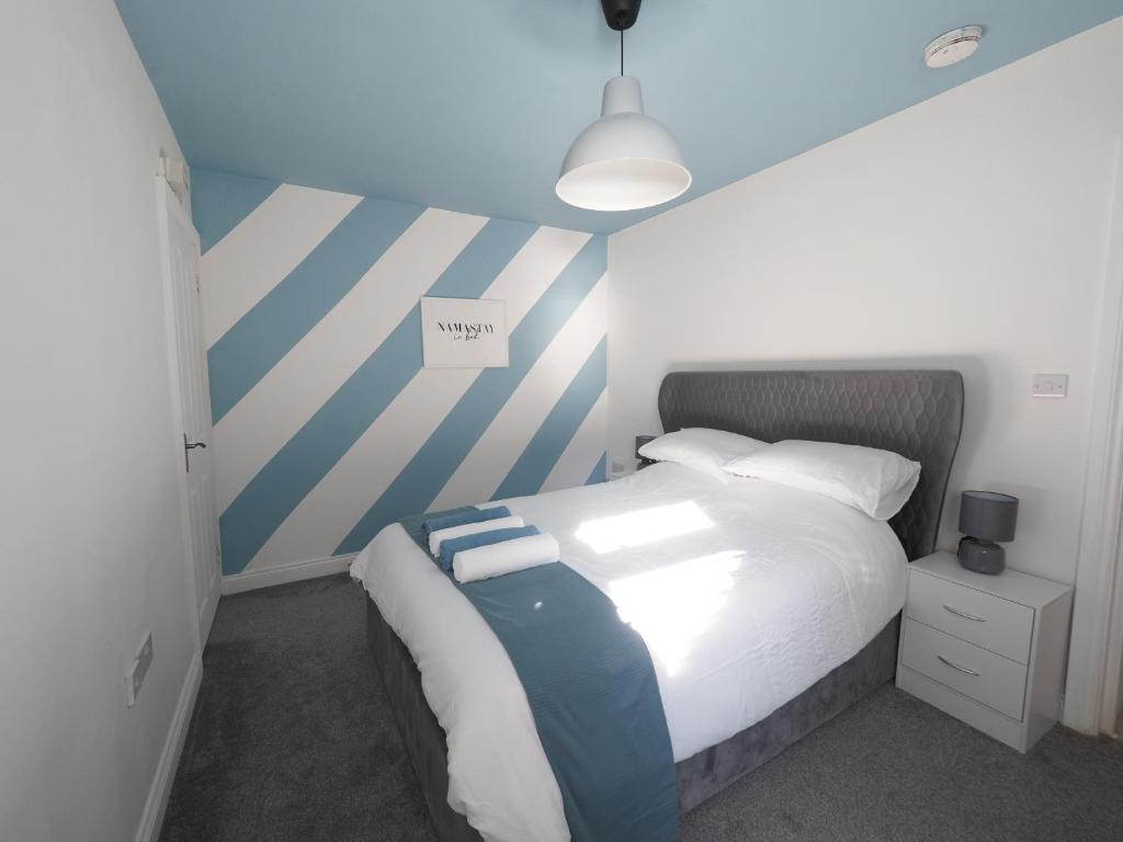 a bedroom with a bed with blue and white stripes at Grosvenor Suite in Royal Tunbridge Wells