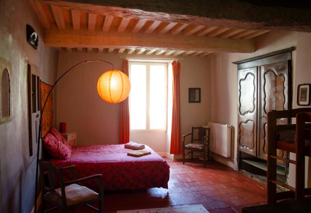- une chambre avec un lit rouge et une fenêtre dans l'établissement Gîte de charme cévenol, à Cros