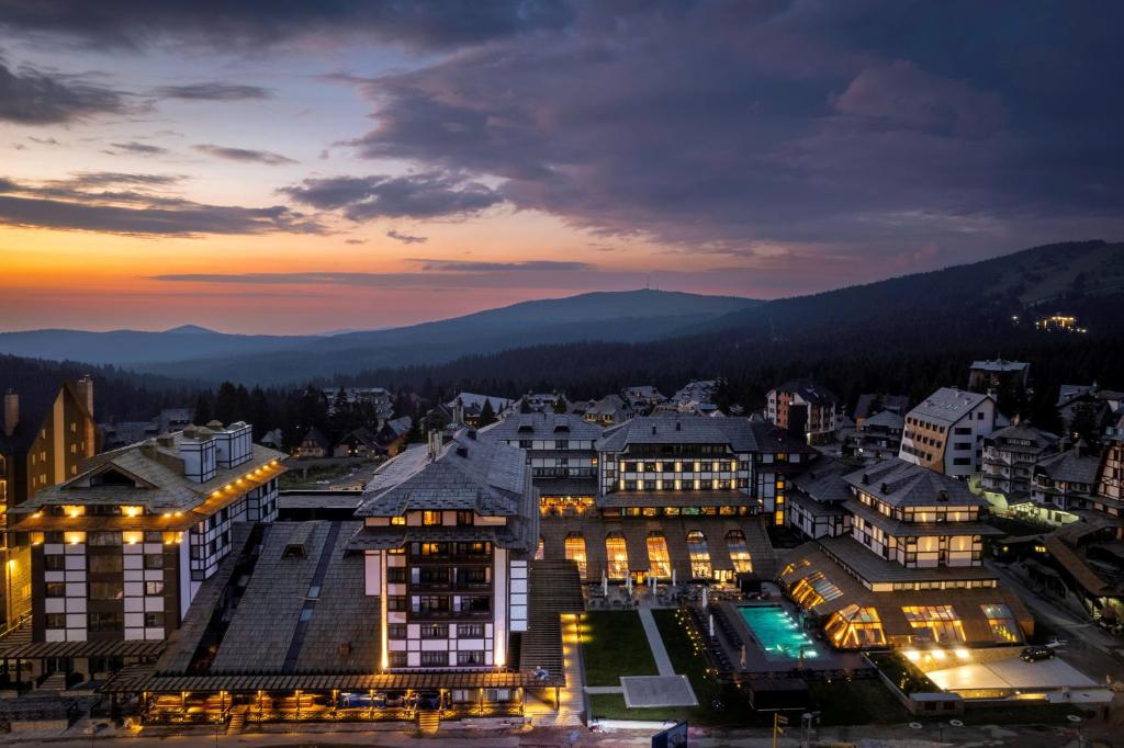 Una ciudad de noche con las montañas al fondo en Hotel Grand Kopaonik, en Kopaonik