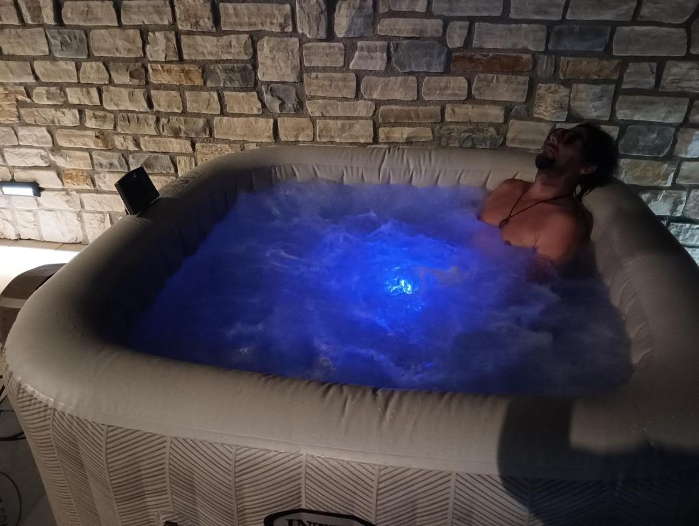 a man is sitting in a hot tub at Kuća za odmor MARIA in Vodice