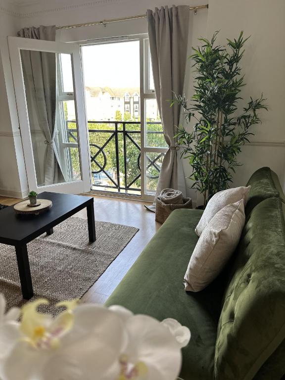 sala de estar con sofá verde y mesa en Large 2 Bedroom Marina View Apartment en Hemel Hempstead