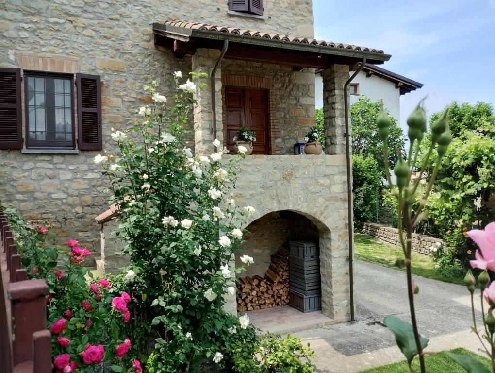 a stone house with a brick oven in a garden at La Pomella in Ponte Nizza