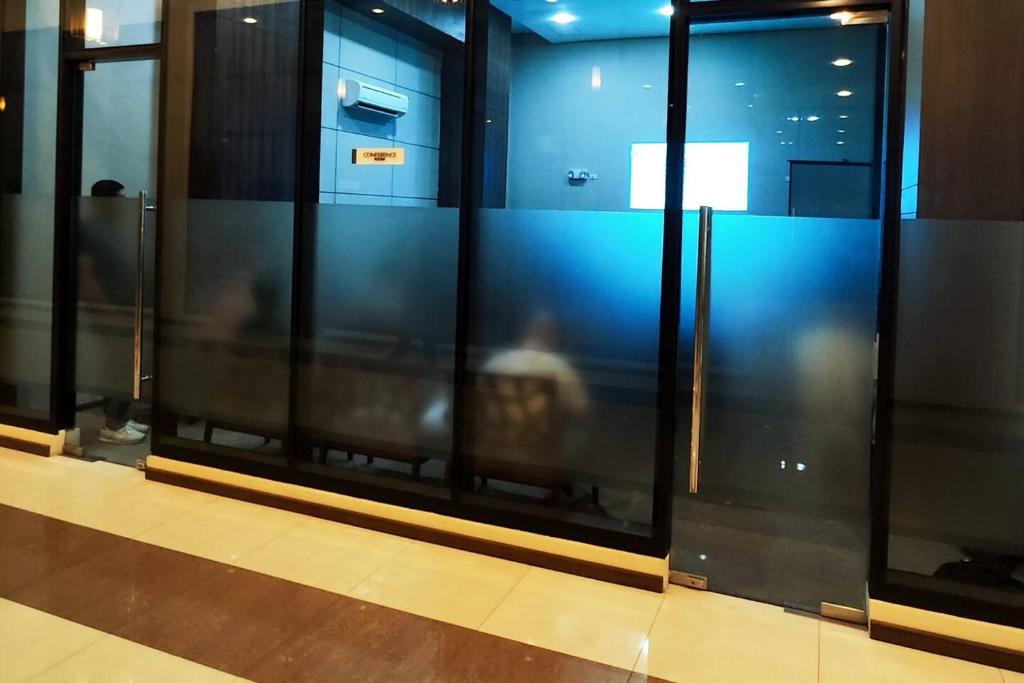 a group of glass windows with a person in the reflection at 1 Bedroom with balcony azalea condo in Cebu City