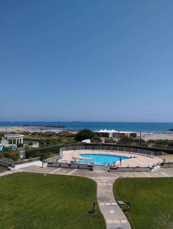 - une vue sur la piscine et la plage dans l'établissement Appartement Vue mer Le Sunset, au Cap d'Agde