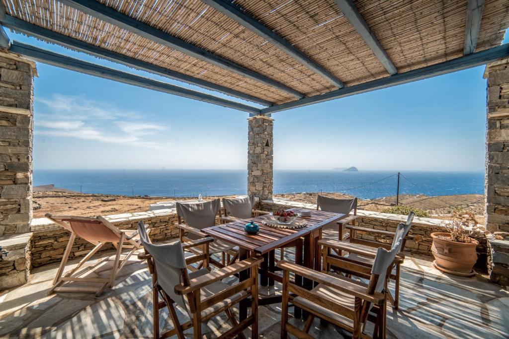 a patio with a table and chairs and a view of the ocean at Alas Residence Liotrivi Kythnos in Kithnos