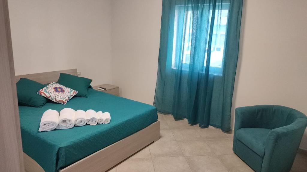 a bedroom with a green bed with a blue chair at Lovin Puglia Vacation in Bari