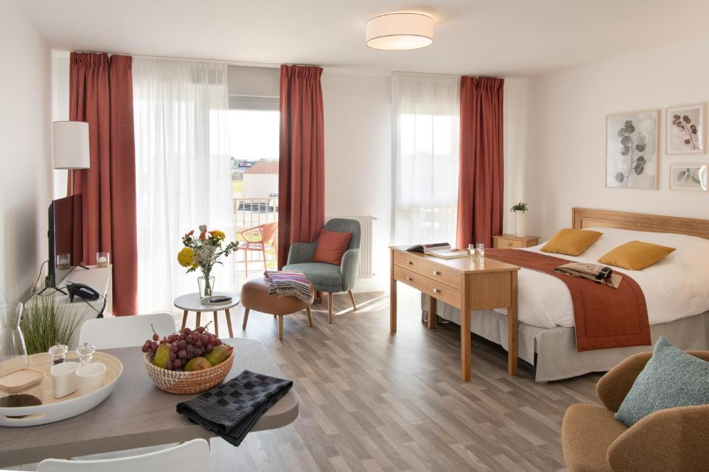 a hotel room with a bed and a living room at DOMITYS LES CERNEAUX in Hazebrouck