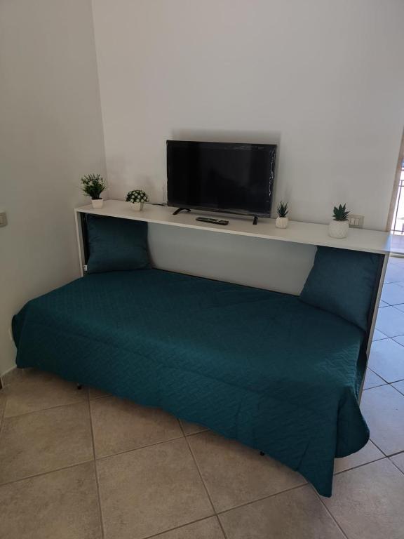 a room with a couch with a tv on a wall at Lovin Puglia Vacation in Bari