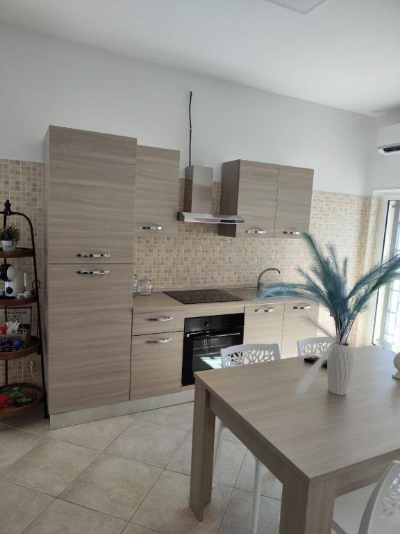 a kitchen with wooden cabinets and a table with a plant at Lovin Puglia Vacation in Bari