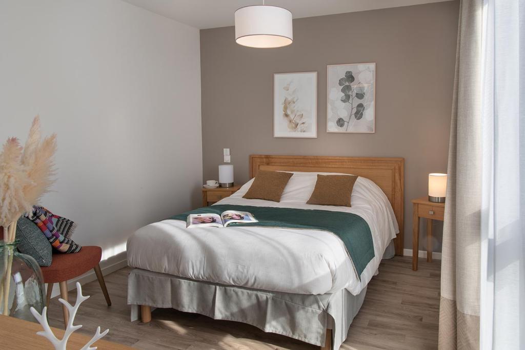 a bedroom with a bed and a table and a chair at DOMITYS LES CERNEAUX in Hazebrouck