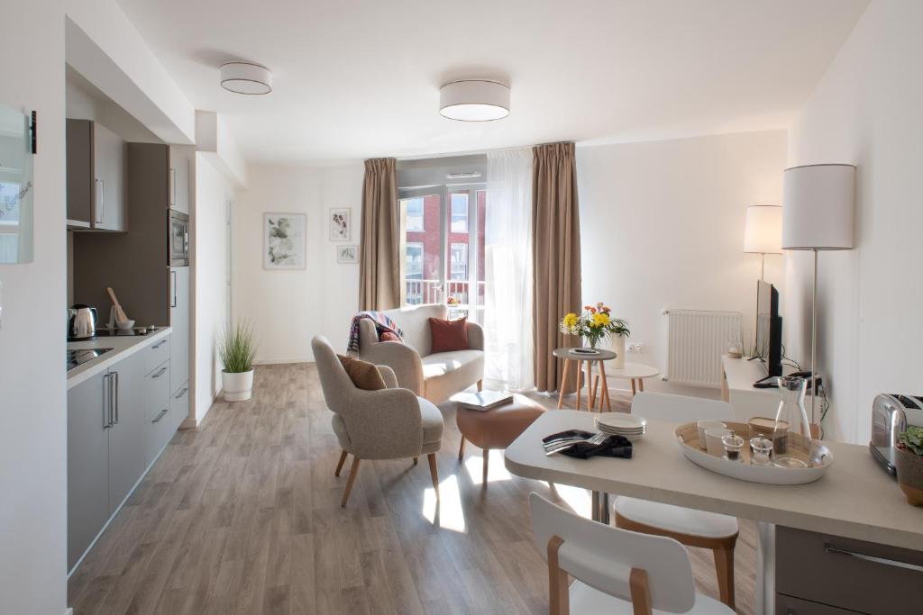 a white living room with a kitchen and a living room at DOMITYS LES CERNEAUX in Hazebrouck