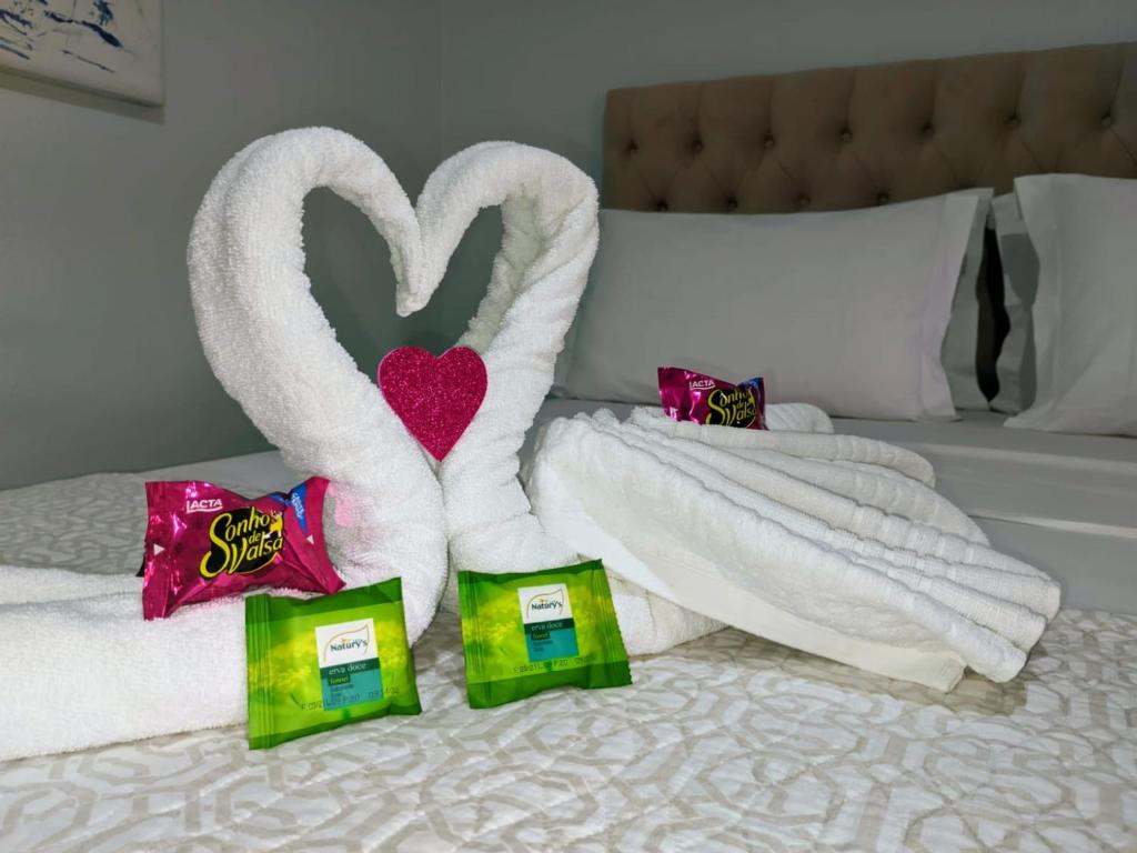 a pair of towel swans sitting on top of a bed at Pousada Mar e Cia in Ilha do Mel
