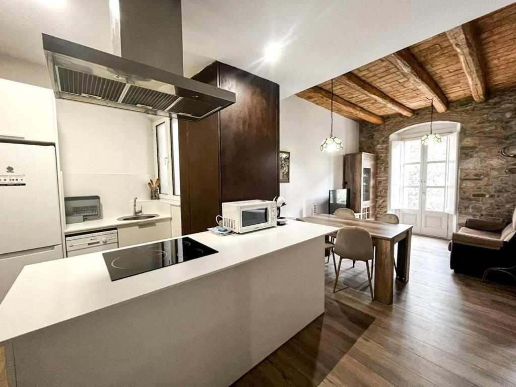 a kitchen with a counter top and a dining room at Maravilloso apartamento en el casco antiguo in Besalú
