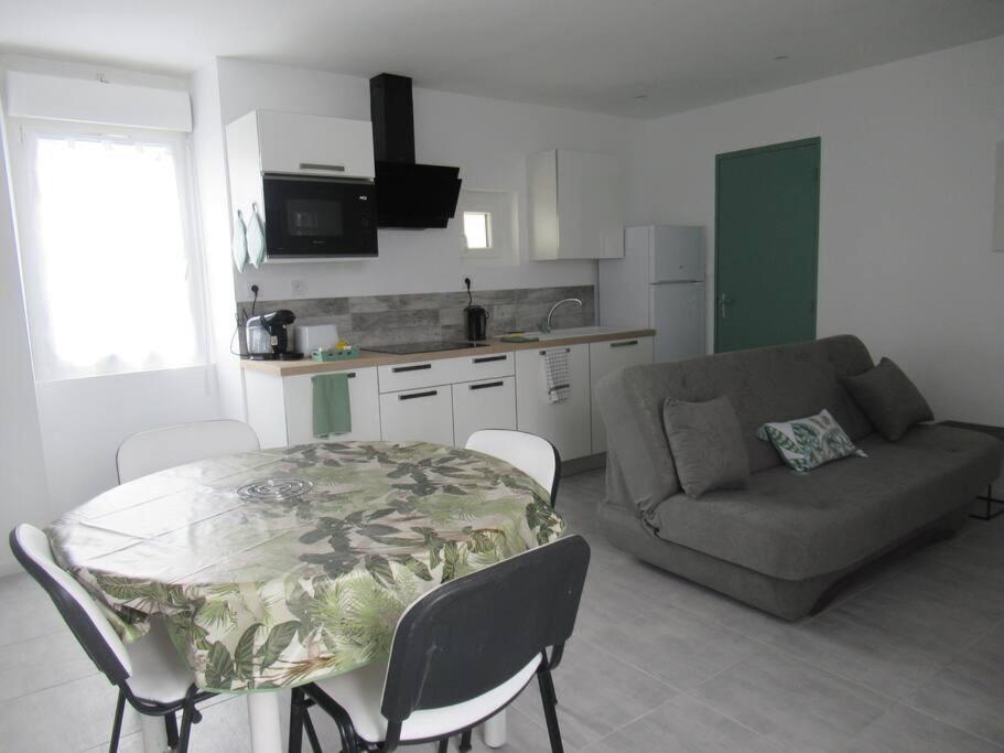 un salon avec une table et un canapé dans l'établissement Gîte la Chaumette appartement Emeraude, à Villeuneuve-de-Berg
