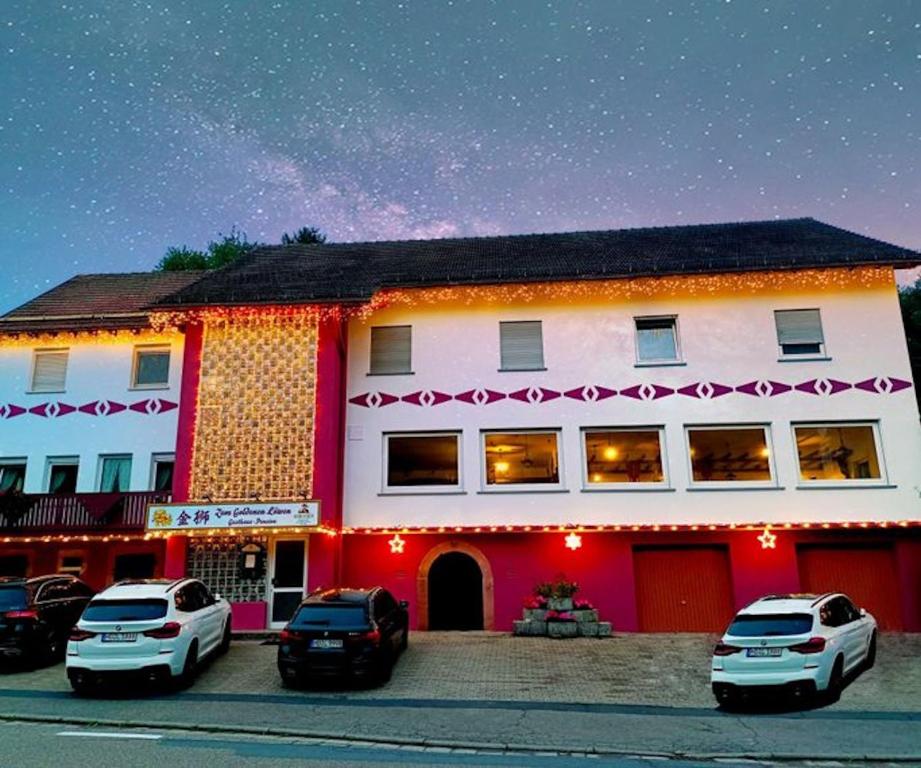 een gebouw waar auto's voor geparkeerd staan bij Gasthaus Zum goldenen Löwen in Finkenbach