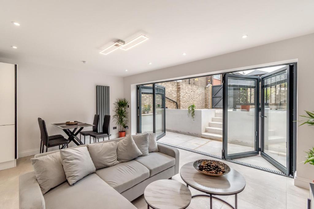 a living room with a couch and a table at Modern Garden Flat with Private Parking in London