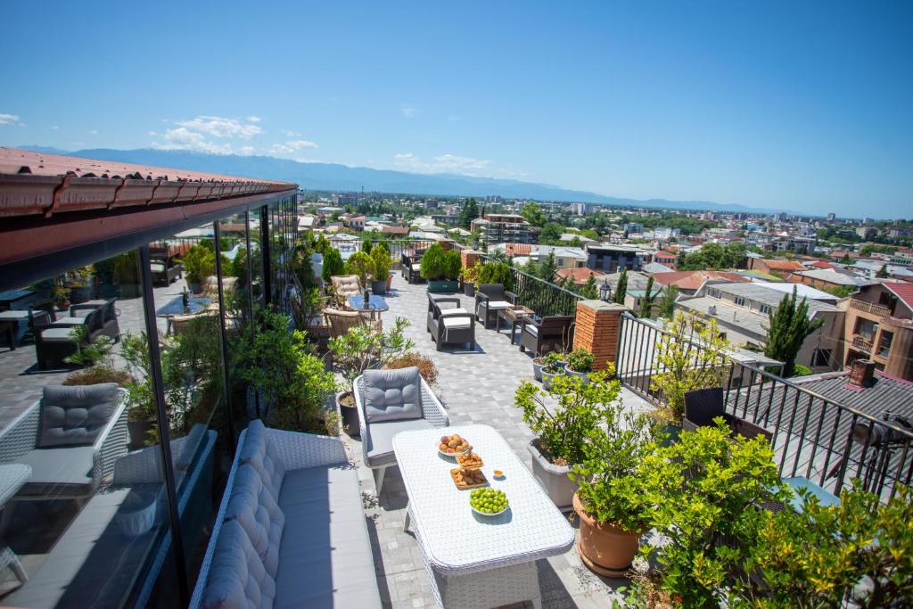 a balcony with a table and chairs and a city at Hotel Terrace Kutaisi in Kutaisi