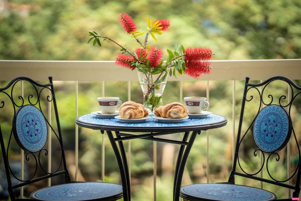 - une table avec deux pâtisseries et un vase avec des fleurs dans l'établissement Ammare Bed & Breakfast, à Marina di Camerota