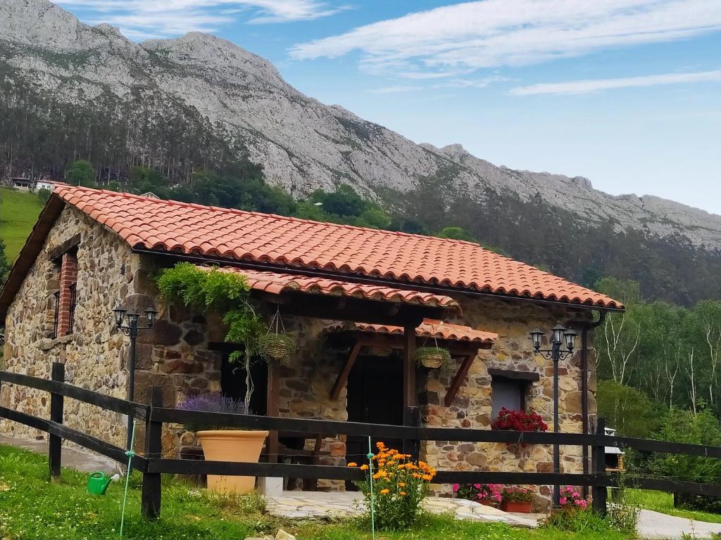 una pequeña casa de piedra frente a una montaña en Cabaña Jerreru (vivienda vacacional), 