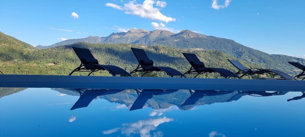 a row of chairs with mountains in the background at Le Refuge du Montagnard in Marthod