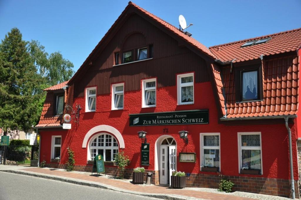 a red building on the side of a street at Hotel & Restaurant Märkische Schweiz in Buckow