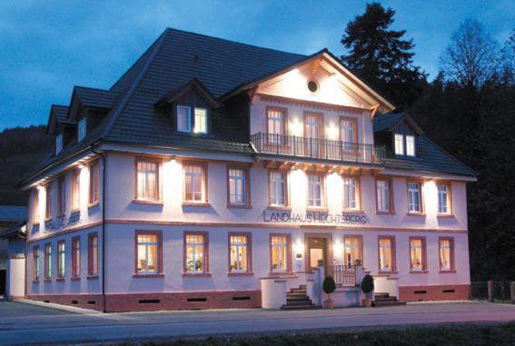 un grand bâtiment blanc avec un toit noir dans l'établissement Landhaus Hechtsberg, à Hausach