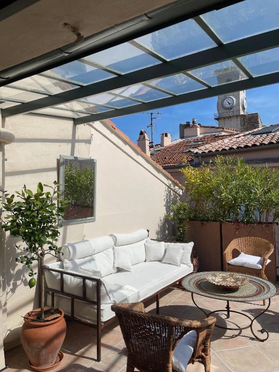 une terrasse avec un canapé blanc et une table dans l'établissement La Maison, à Cannes
