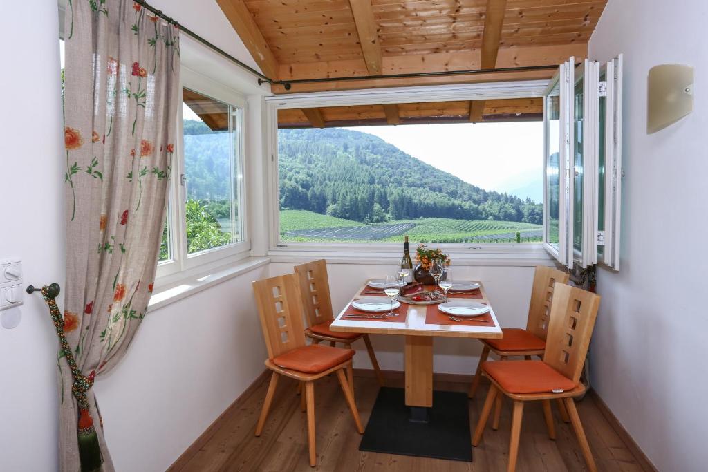 comedor con mesa, sillas y ventana en Waldthalerhof, en Monticolo