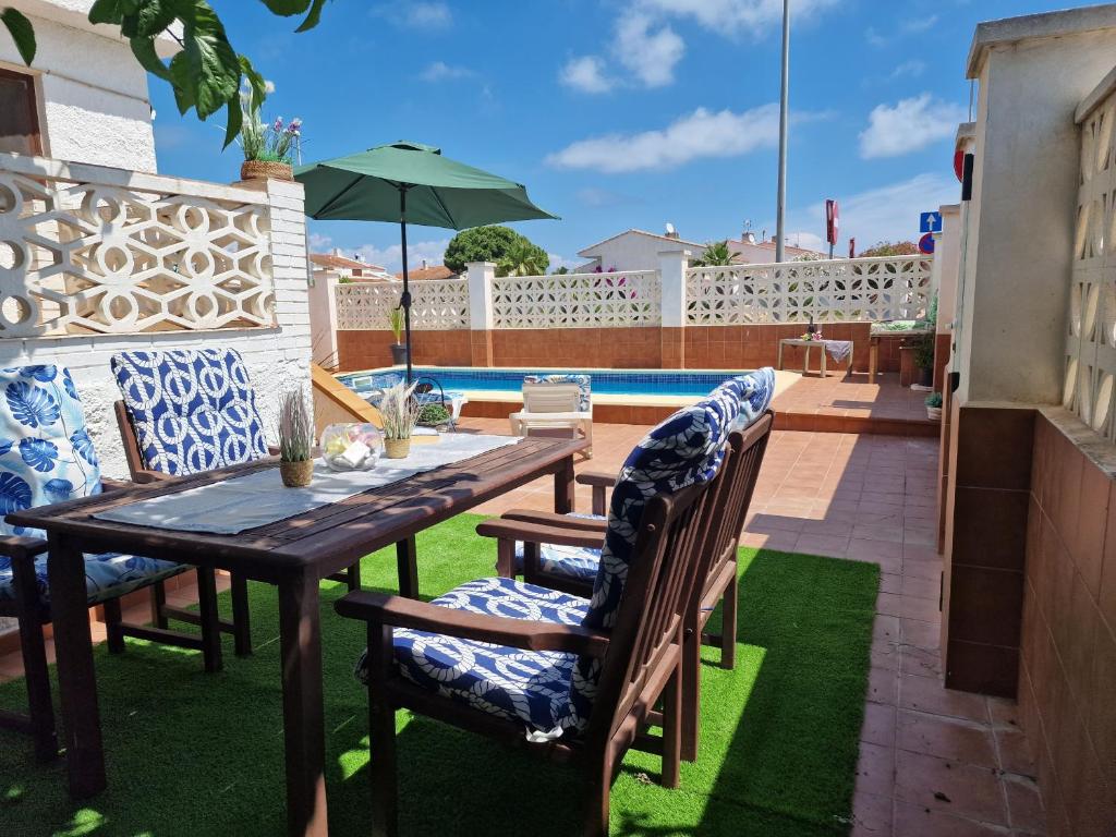 a patio with a table and chairs and a pool at Riumar "Camins", 380m to beach, private pool, On-Site-Service, dog beach in Riumar
