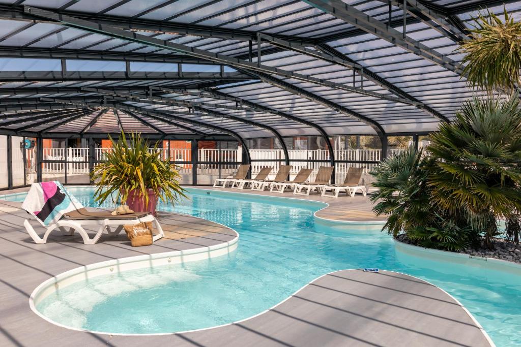 a large swimming pool with a metal roof at Camping Park Er Lann in Saint-Pierre-Quiberon